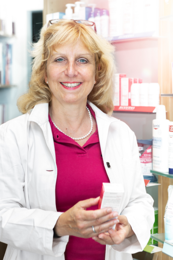 Caren Ahnefeld hält ein Produkt in der Hand und lächelt in die Kamera.
